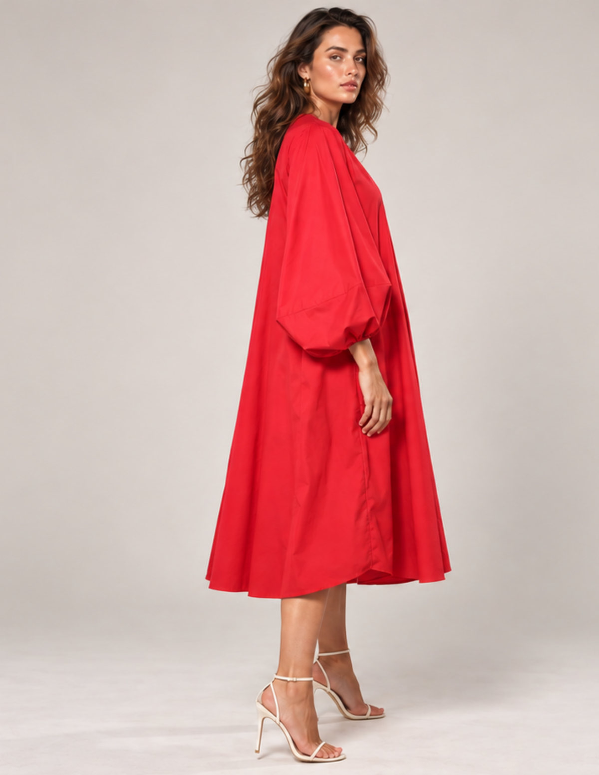 Woman wearing a red Lili Dress with long puff sleeves, relaxed A-line silhouette and side pocket shown from the side