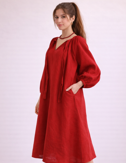 Bianca dress sewing pattern sewn in red fabric, three-quarter view showing long sleeves and flowing silhouette