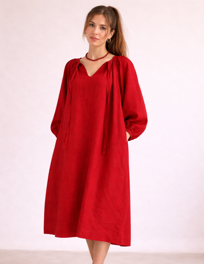 Bianca dress sewing pattern sewn in red fabric, front view with gathered neckline and voluminous sleeves