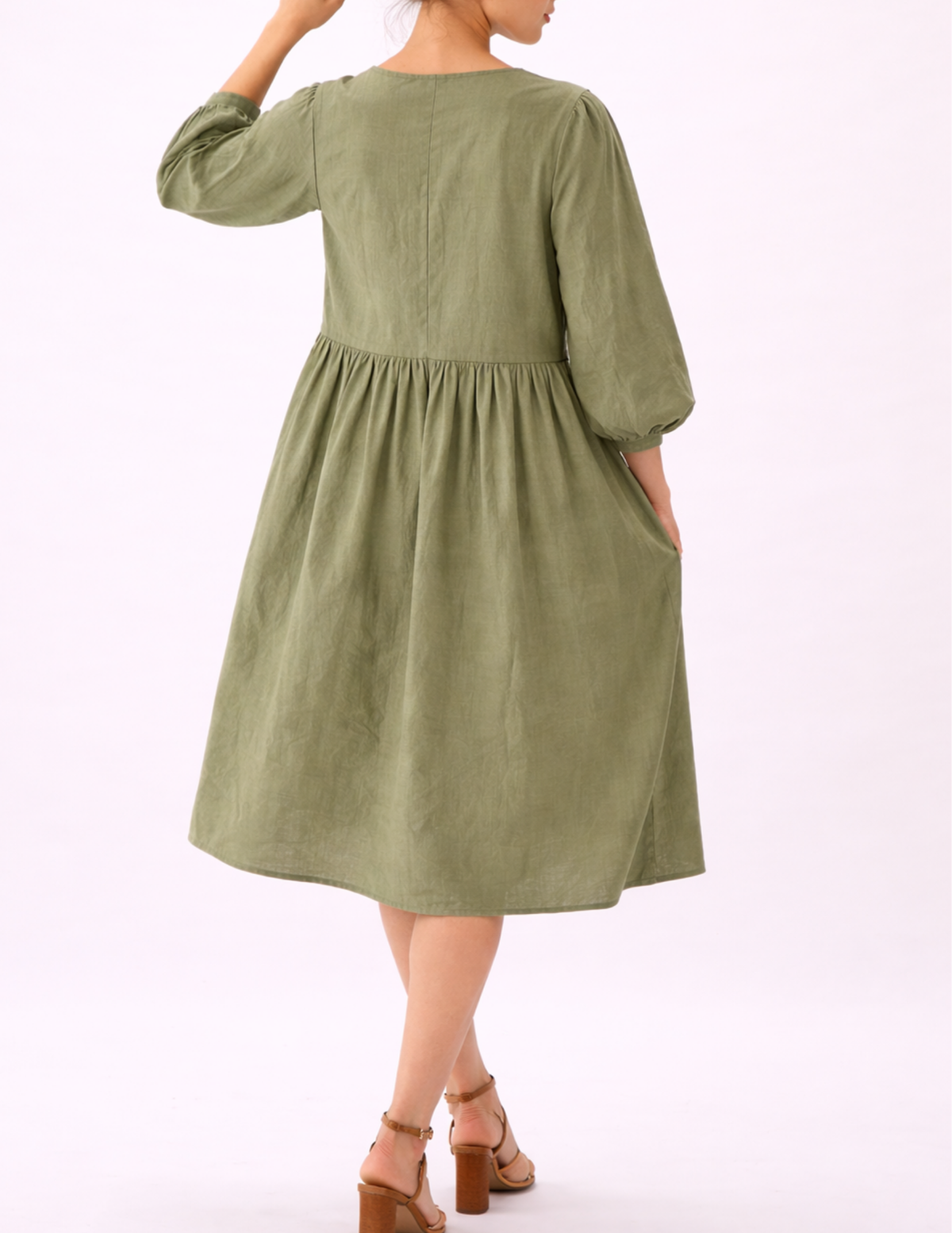 MIMA dress sewing pattern shown from the back, featuring a gathered skirt, long puff sleeves and a relaxed midi silhouette in sage green linen